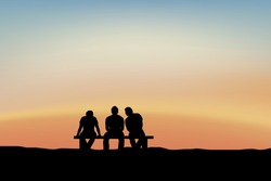 men sitting and talking at sunset