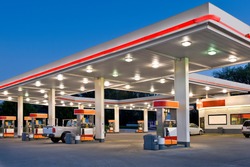 Horizontal shot of a retail gasoline station and convenience store at dusk.