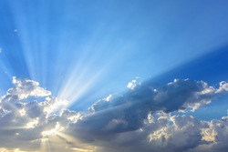 Sun beams or rays breaking through the dark clouds at sunset. Hope, prayer, God's mercy and grace. Beautiful spectacular conceptual meditation background.