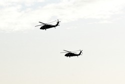 Silhouette of two military transport helicopters in the clear sky above Israel and Gaza Strip.