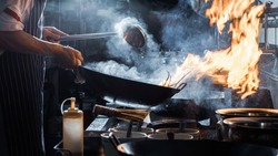 Chef is stirring vegetables in wok, vintage filter