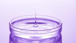 Drop of water falls down into petri dish with clear fluid creating ripples on its surface on violet background | Abstract skin moisturizing cosmetics formulating concept