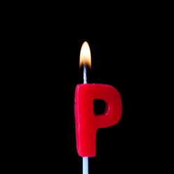 Letter P celebration birthday candle against a black background