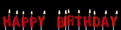 Happy Birthday spellt out in red candles against a black background