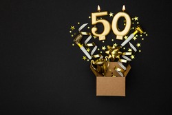 Number 50 gold celebration candle and gift box background