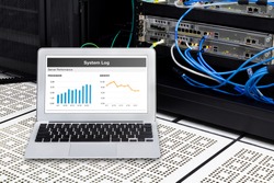 Laptop in network data center, server room. Using for monitoring server computer performance.