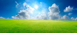 Green grass field and blue sky with white clouds,panoramic view.