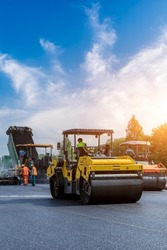 Construction site is laying new asphalt pavement. road construction workers and road construction machinery scene. Highway construction site scene in China.