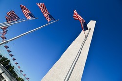 Washington Monument with waving United States flags on flagpoles - Washington DC United States