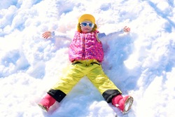 Happy child enjoying winter holidays in Alpine resort in Austria. Little girl playing in the snow. Active sportive toddler learning to ski. Kids having fun outdoors. 