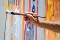 Professional painter at work, painting a street wall