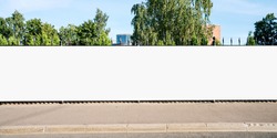 Advertising empty long white billboard with space for mockup information at urban street front view