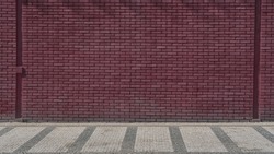 Maroon colored brick wall background front view. Large brickwall at city street.