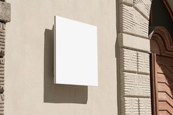 Empty white signage with dark shadow hanging on concrete wall of urban building. Logotype and branding commercial concept.
