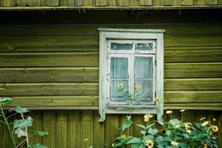 Old rustic wooden yellow painted house with white window frame exterior front view
