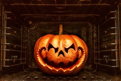 Funny Halloween pumpkin resembling a Chinese dragon head,  roasting in a dirty oven