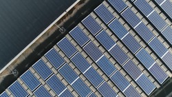 Aerial top down photo of solar panels PV modules mounted on flat roof photovoltaic solar panels absorb sunlight as a source of energy to generate electricity creating sustainable energy