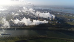 Aerial picture of nuclear power plant and cargo vessel barge moving over canal a thermal power station in which the heat source is a nuclear reactor this plant is located in a heavy industrial zone