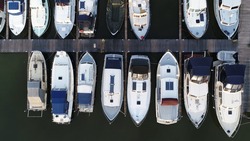 Aerial top down view of marina and docked recreational boats showing the basin with moorings for small vessels