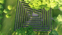 Aerial photo medium altitude above bush maze showing different paths just one leading to exit also known as labyrinth is path or collection of paths typically from entrance to goal drone top-down view