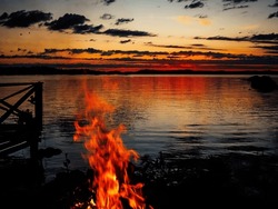 Midsummer fires on a lake side while sunset turning to sunrise. 