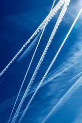 the contrails of multiple aircraft in front of blue sky