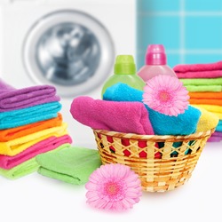 Laundry Basket with colorful towel and washing machine.