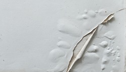 Problem of acrylic white color painting crack abstract surface texture on exterior concrete wall background by humidity.concept for repair old construction
 or vintage renovation home. 