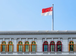The Flag of Singapore fluttering over the Ministry of Communications and Information. Singapore is a popular tourist destination of Asia.