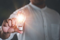 Businessman holding a bright light bulb. Concept of Ideas for presenting new ideas Great inspiration and innovation new beginning.