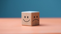 Mental health and emotional state concept, Smile face in bright side and sad face in dark side on wooden block cube for positive mindset selection.