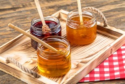 Various fruit marmalade jams in jars top view. Honey, apricot jam and strawberry jam in jars.