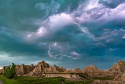 An active lightning storm over the mountains of Badlands National Park in South Dakota lights up the sky.