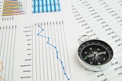 Navigation in financial world, compass on financial charts and graphs