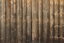 Background texture of a wooden fence or wall with upright natural brown poles in a tight configuration, full frame