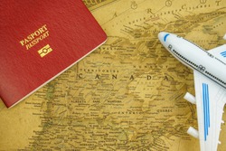 Close up on Canada map with passport and toy aircraft. Travel concept. Canada is a country in the northern part of North America.