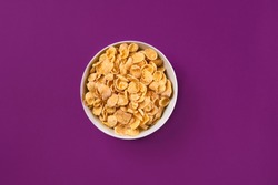 Bowl with cornflakes on the colorful background