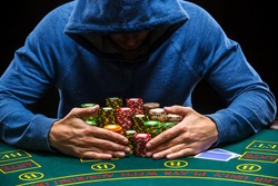 Poker player taking poker chips after winning