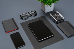 A set of black office accessories, glasses, green flower and smart on gray background
