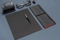 A set of black office accessories, glasses on gray background