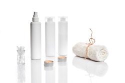 Set of cosmetic products in white containers on light background.