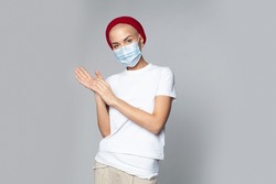 young attractive female with butch cut hairstyle and medical face mask isolated on gray background
