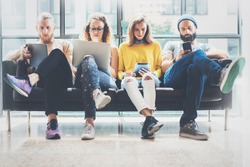 Group Adult Hipsters Friends Sitting Sofa Using Modern Gadgets.Business Startup Friendship Teamwork Concept.Creative People Working Together Marketing Project.Coworking Process Office Studio.Blurred