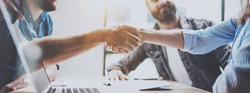 Business partnership handshake concept.Photo two coworkers handshaking process.Successful deal after great meeting.Horizontal, blurred background.Wide
