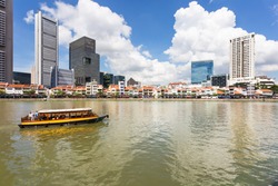 Tourist boat on the Singapore river along the Clark Quay on a sunny day in Singapore in Southeast Asia.