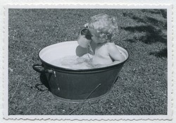 Vintage photo (1955) of baby taking a bath in a washtub