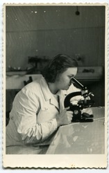 Vintage photo of young female doctor with microscope (early fifties)