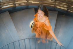 Portrait beautiful young asian woman walk on circle stair with smile and happy