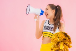 Portrait beautiful young asian woman cheerleader with megaphone on pink isolated background