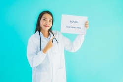 Portrait beautiful young asian doctor woman with sign paper with social distancing word for protect from covid19 or coronavirus